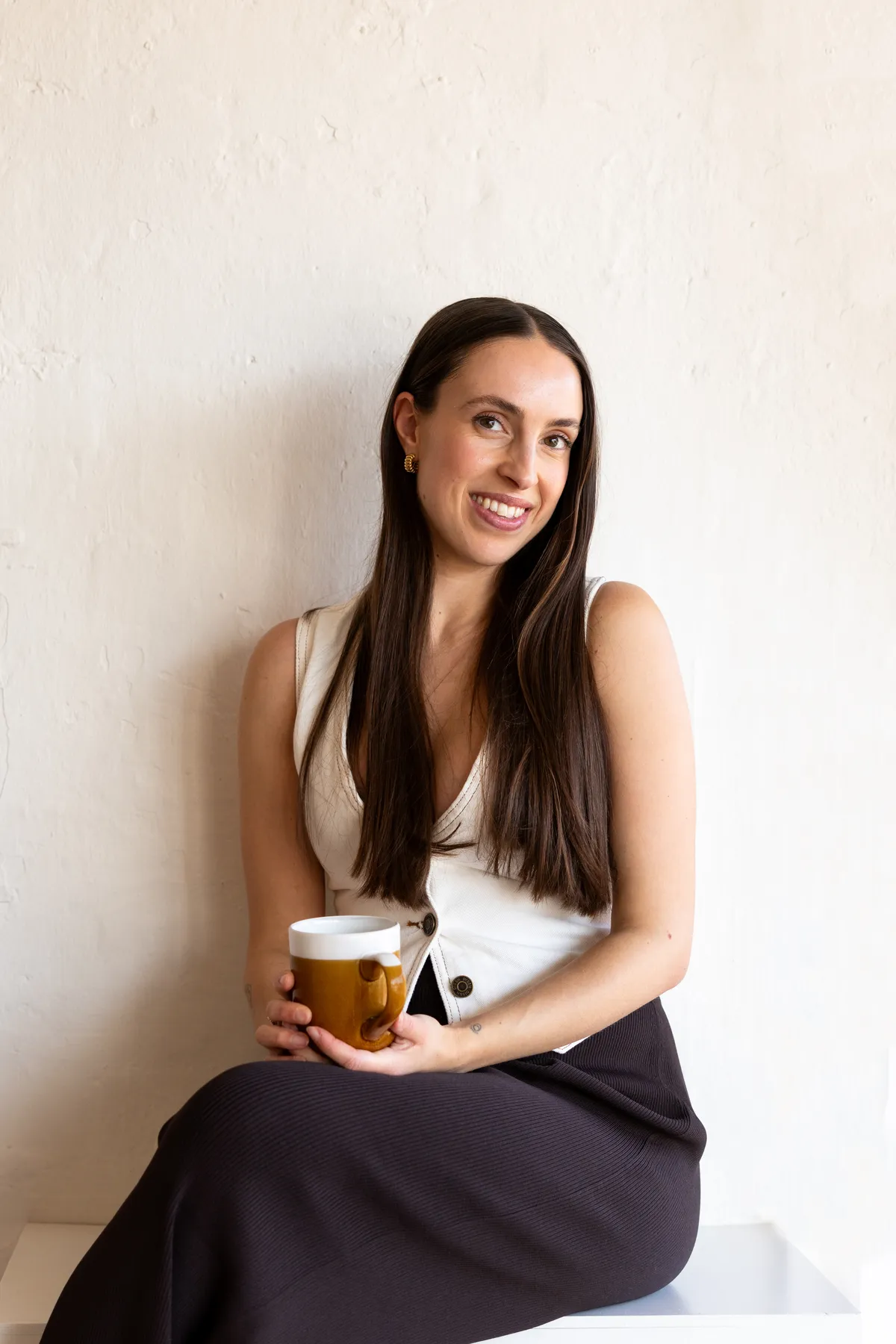 Amelia La Rosa, naturopath in Melbourne & Sunbury, seated with a cup of herbal tea