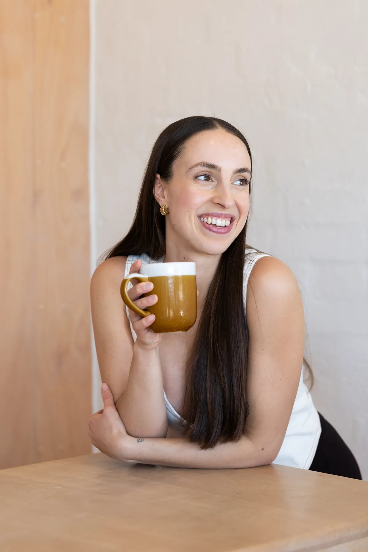 Portrait of Amelia La Rosa, qualified naturopath and yoga teacher, smiling with a cup of tea