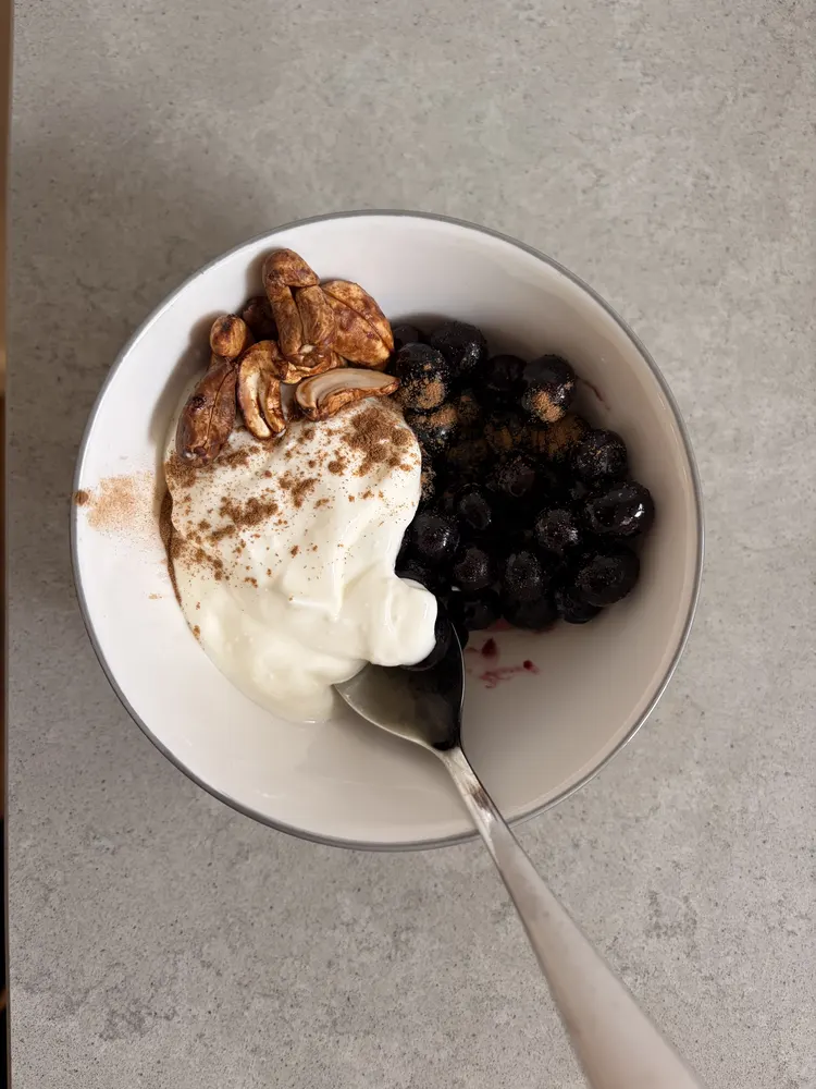 Greek yoghurt with blueberries and roasted cashews, dusted with cinnamon